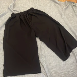 Black knee-length pants - Size is M - but due to its stretchable waistline - it is suitable for S too. Wore a couple of times but still relatively good in condition. Please note that the material is thin and soft, but no see-through