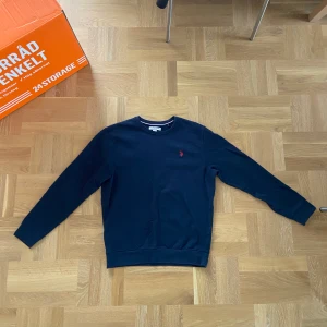US polo Ralph Lauren tröja  - US polo Ralph Lauren tröja i storlek M för herrar. Fin marinblå färg med röd logga som bryter av. Bra plagg, använd men i ett gott skick. 