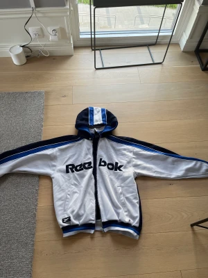 Reebok tjocktröja - Vintage Reebok, luvan går att ta av och på. Thriftade den. Står ingen storlek men den passar på mig (177) skulle gissa på M