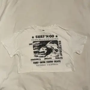 Vit croppad t-shirt från H&M, fint tryck på💖 Aldrig använd så i nyskick✨ Frakt tillkommer📦