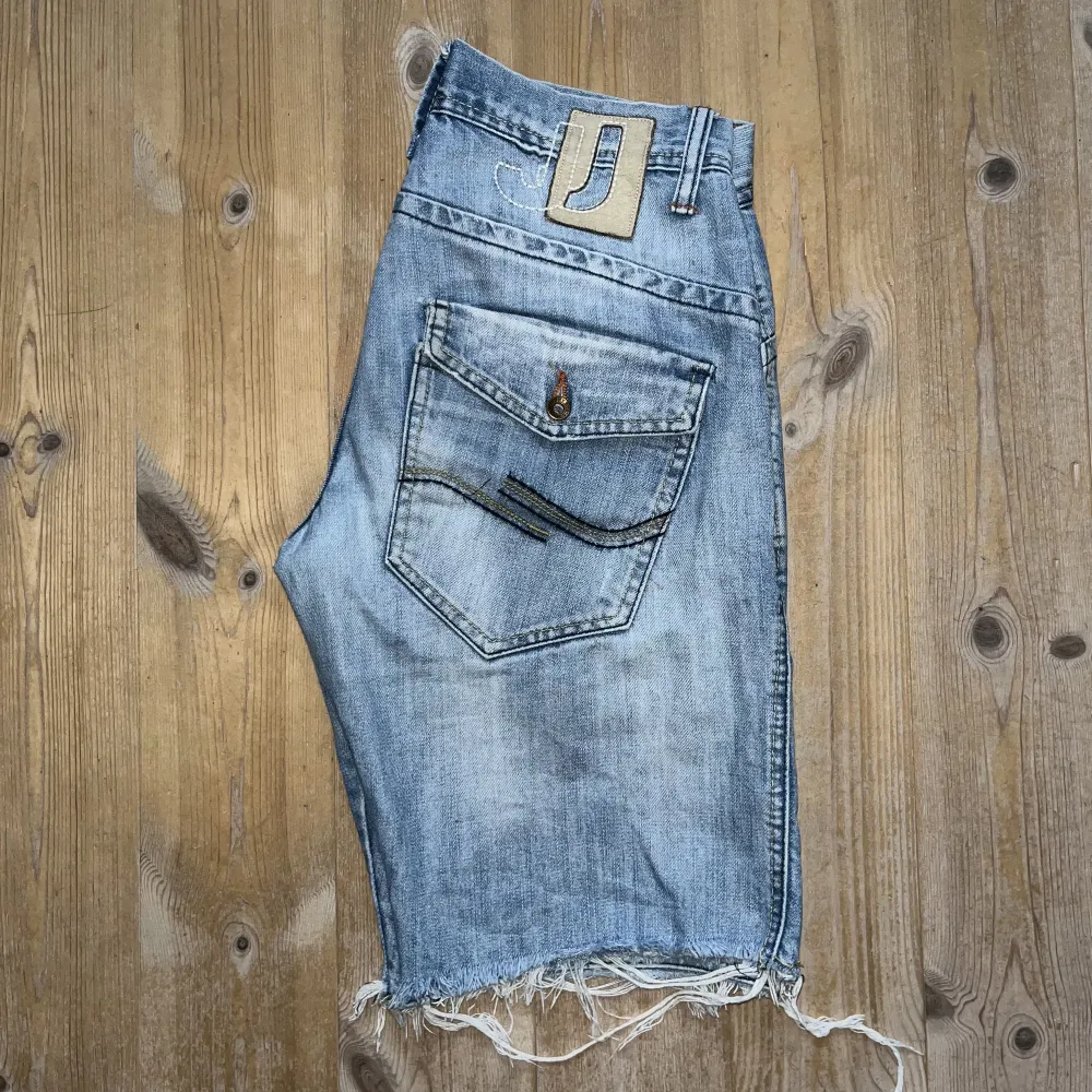 Vintage low waisted Jack&Jones jeansshorts. Fina detaljer i sömmar och knappar. Sitter på mina höfter (34) Köpta secondhand. Snyggt med enkel tisha och mycket smycken. Shorts.