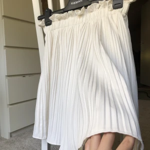 Plisserad kjol - Supersöt vit plisserad kjol från gina tricot. Storlek 38, men skulle säga att den även passar både 36 och 40. Har en superelastisk midja! Går till över knät på mig som är 168cm lång. Aldrig använd, så nyskick! 🤩