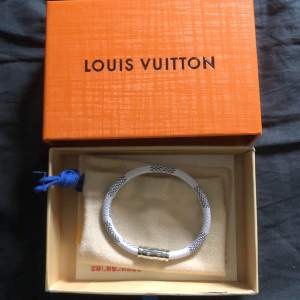 Ett stiligt 1:1 Louis Vuitton-armband i vitt. Sprillans nytt, inga tecken på användning. Låda och dustbag medföljer. Metallen är silverfärgad. Passar handleder under 20 cm i omkrets