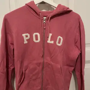 Hoodie med dragkedja från Ralph lauren! Den har stort tryck, är rosa och i bra skick. I storlek xs/s💕