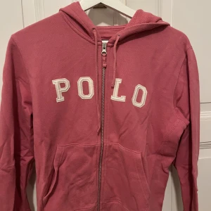 Polo zip up hoodie - Hoodie med dragkedja från Ralph lauren! Den har stort tryck, är rosa och i bra skick. I storlek xs/s💕