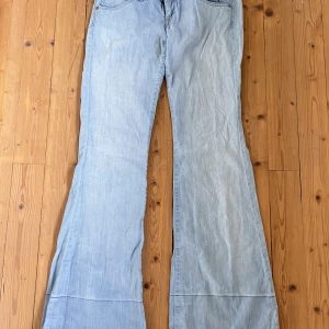 Lågmidjade Lee Jeans - Lågmidjade ljusblåa jeans från Lee som är utsvängda nertill