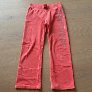 Juicy couture byxor korallrosa - Säljer dessa p.g.a för små. Cirka 72 cm. Storlek 6/7 men är stora i storleken. Gamla modellen❤️❤️ Skulle kunna passa tills man blir ungefär 8-9. 