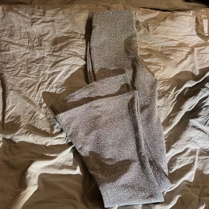 Glitterbyxor - Glittriga utsvängda byxor/leggins. Använda 1 gång. Bra längd på mig som är 170cm. Köpare betalar frakt.