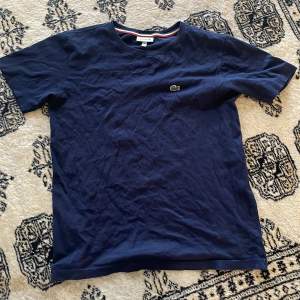 En snygg Blå Lacoste t shirt för barn, kommer stryka tröjan innan försäljningen 