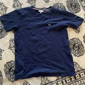 En snygg Blå Lacoste t shirt för barn, kommer stryka tröjan innan försäljningen 