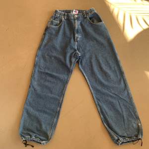 Baggy mörkblåa jeans från District 46, drawstrings vid fötterna och strechig midja, knappast använda och i bra kondition.