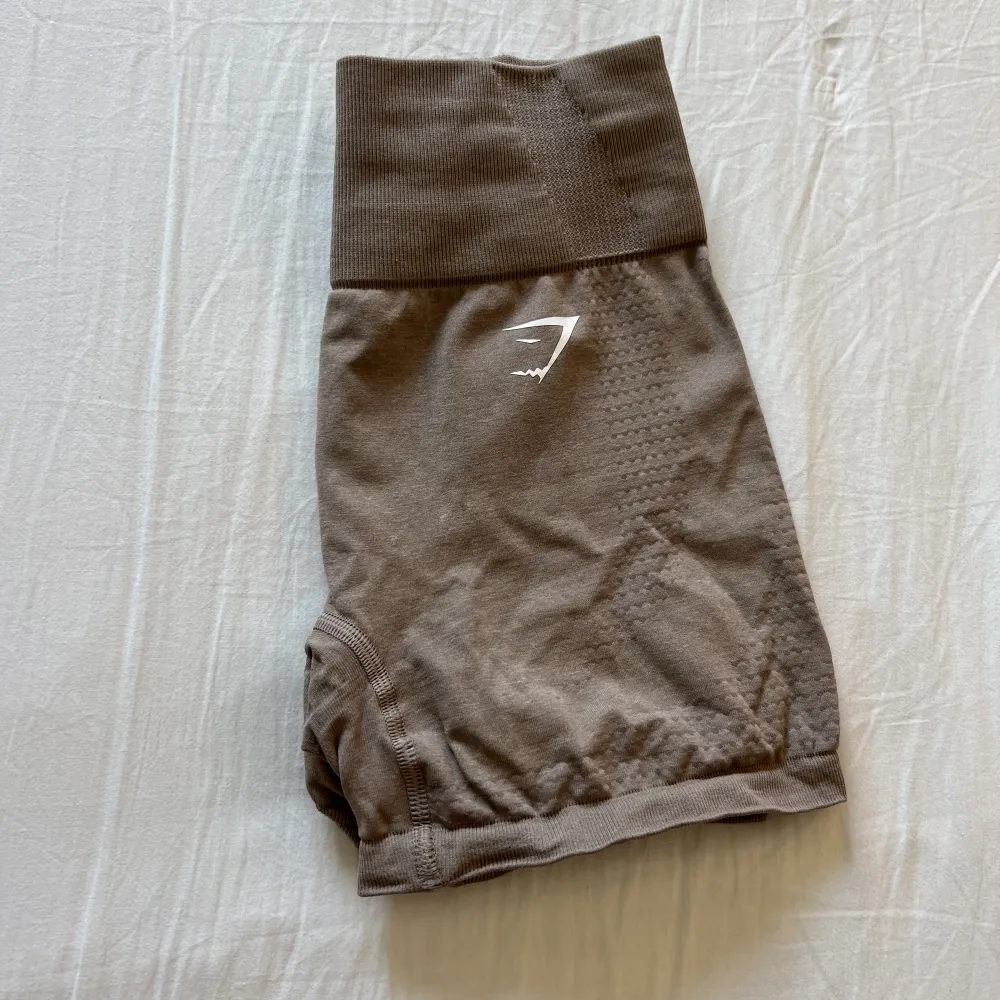 Bruna gymshark shorts storlek S, knappt använda och endast skrynkliga pågrund av att de legat länge i garderoben utan användning, kan tvättas och strykas innan postning så blir dom som nya💕. Shorts.
