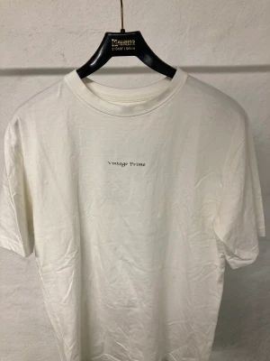 Vintage prime (Elias monten limited edition) - En vit t shirt som har ett ankare på ryggen som är disignad av Elias monten, denhör kollektionen är limiterad vilket gör den extra unik, använd ett fåtal gånger, inga skador eller liknande