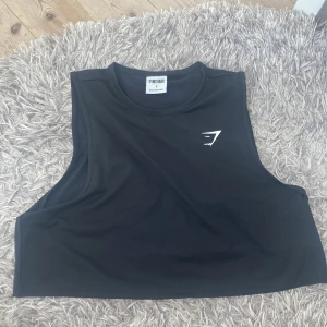 Gymshark linne - Ett svart linne ifårn gymshark i storlek S🤗har bara använt 1 gång så den är som ny. Jag är 173 cm och den sitter bra på mig
