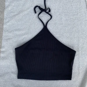 Topp - Simpel svart topp funkar till fest och vardagligen. Öppen där bak så man bara knyter i nacken.