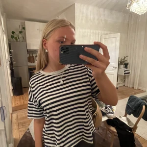 Randig T-shirt  - Säljer denna T-shirt från Zara köpt förra sommaren. Är lite coolare än de andra randiga då den skiljer sig i längden på framsida respektive baksida, visas på andra bilden!!