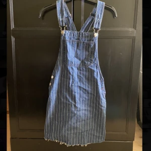 Hängselklänning  - Aldrig använd!! Hängselklänning i storlek XS köpt i Spanien från Bershka för några år sedan. Har fickor på baksidan och på framsidan.