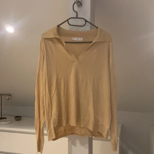 Långärmad tröja - Gulfärgad långärmad tröja från mango, har ett litet streck på överdelen av tröjan.