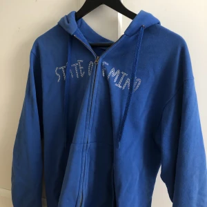Blå hoodie  - Säljer min blåa Rhinestone zip up hoodie. Bra skick, säljer då den ej kommer till användning. Nypris 800kr