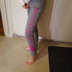 Träningsbyxor  - Snygga grå träningsbyxor med rosa text