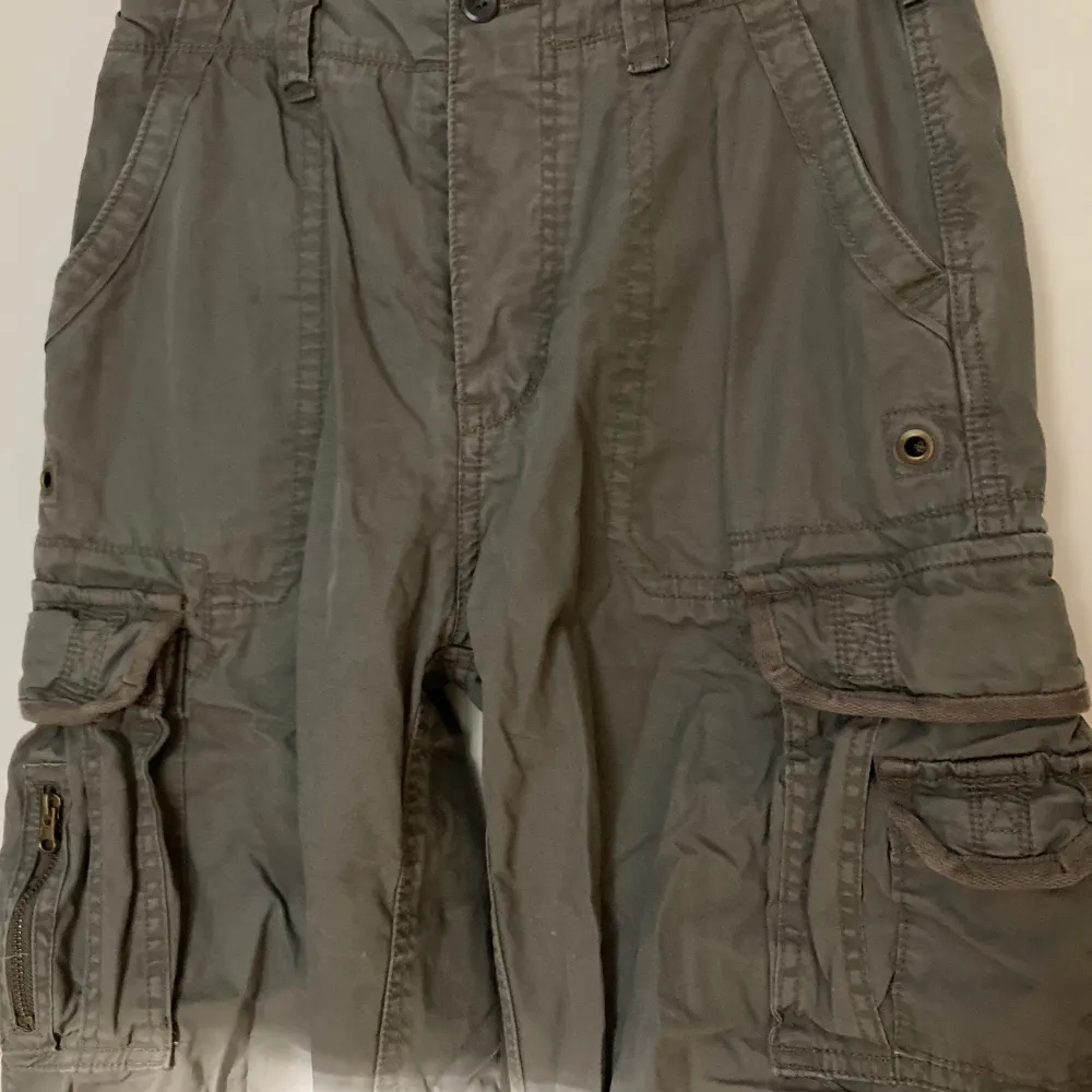 Brandit cargobyxor i camofär, många fickor + snören i midjan och benen för att justera storlek :). Jeans & Byxor.