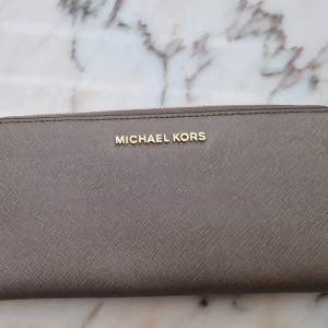 Säljer en plånbok från Michael kors i måtten 21cmx11cm. Nyskick knappt använd.