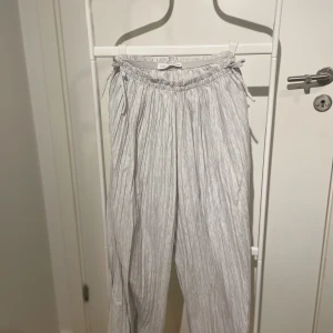 Zara Tygbyxor - Säljer några jättesnygga Zara barn tygbyxor med små rosetter på sidan. Byxorna är väldigt utsvängda och ser nästan ut som man har en kjol på sig när man står rakt. Bra skick💘