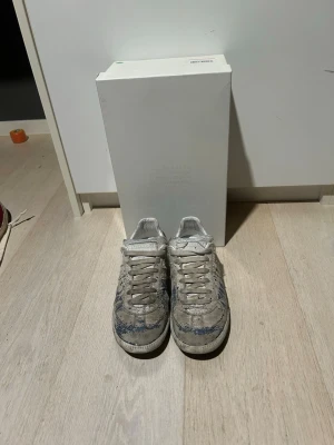 Maison margiela gats  - Säljer ett par maison margiela gats med blå paint splatter. Skorna är synligt använda. Skopåsar och box ingår. Priset är ej hugget i sten.