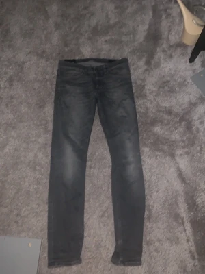Gråa slim fit dondups - Säljer ett par nästan helt oanvända dondup jeans! Jeansen är väldigt trendiga och är tillverkade i stretchigt material för extra komfort. Perfekta till en avslappnad streetwear-look. Inget problem med dom alls.
