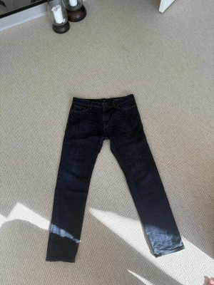 Mörkblå jeans från BOSS Regular Fit - Snygga mörkblå jeans från BOSS i modellen 030 MAINE med regular fit. Klassisk femficksdesign, raka ben och kontrastsömmar. Perfekta för dig som gillar stilrena och tidlösa jeans i ett mjukt denimtyg.