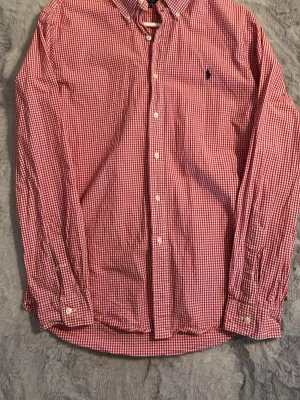 Rödvitrutig skjorta Polo Ralph Lauren - Klassisk röd och vit rutig skjorta från Polo Ralph Lauren i slim fit-modell. Skjortan har lång ärm, knäppning framtill och en liten mörkblå broderad logga på bröstet. Tillverkad i mjuk bomull och perfekt för en stilren look. Storlek L slimfit - mer medium 