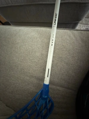 Unihoc innebandyklubba blå/vit - Säljer en Unihoc innebandyklubba med vitt skaft och blått blad. Modellen heter MAX 29 och klubban har ett klassiskt rutmönstrat blad i plast. Perfekt för dig som gillar innebandy och vill ha en lätt och smidig klubba. Ingen grepplinda på