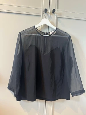 Svart transparent blus - Snygg svart blus i transparent material men täckt ungefär som ett linne! 