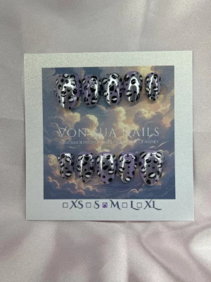 WildViolet (M);ExtraShortAlmond  - Handgjorda press-on naglar med lila bas och svartvitt leopard-mönster. Naglarna har en extra kort mandel form och är tillverkade i M: 16 mm, 12 mm, 12,5 mm, 11,5 mm, 10 mm. Perfekt för dig som vill ha en unik och trendig look.