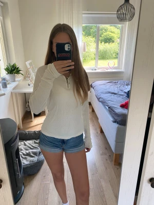 Blå denimshorts i klassisk modell - Säljer ett par blå denimshorts med normal passform och midwaist. Shortsen har en enkel, tidlös look utan synliga detaljer som mönster eller broderier. Perfekta för sommardagar och lätta att matcha med olika toppar.