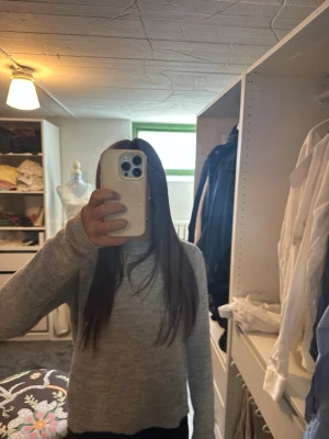 Ljusgrå basic stickad tröja - En enkel och stilren ljusgrå stickad tröja med rund hals och långa ärmar. Tröjan har en mjuk och bekväm passform, perfekt för lager på lager. Passar till jeans eller kjol för en avslappnad look.