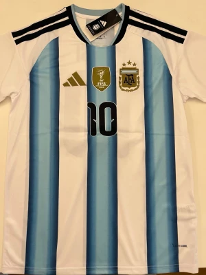 Lionel Messi Argentina Vm 2026 - Fotbollströja i helt nytt och oanvänt skick med tag kvar. Detaljrik design och bekvämt material som passar både till match och vardag. Detta är en inofficiell version av modellen. Storlek M