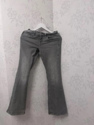 Low waisted Gråa flared jeans - Gråa flared jeans från Gina tricot med mönster på fickorna, i storlek 40
