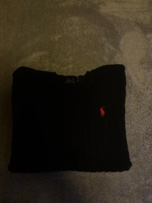 Svart kabelstickad tröja Polo Ralph Lauren - Kabelstickad svart tröja från Polo Ralph Lauren, säljer att den är lite för tajt vi ärmarna och för lös i midjan på mig. 