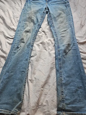 Ljusblå bootcut jeans - Säljer ett par ljusblå jeans med klassisk bootcut passform. Jeansen har fem fickor, normal midja och är tillverkade i ett mjukt denimtyg. Perfekta för dig som gillar en retro och avslappnad stil.