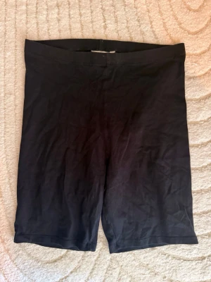 Svarta cykelshorts - Svarta cykelshorts i stretchigt material med midja utan synliga detaljer. Perfekta för en avslappnad och sportig stil. Passar till många olika outfits och är riktigt bekväma.