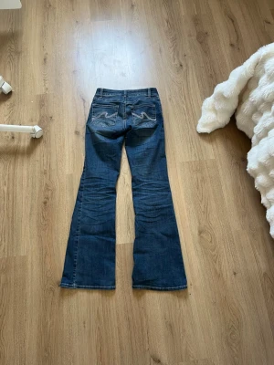 Mörkblå bootcut jeans med broderi -  Mörk blå jeans från Nelly i storlek 34. Säljer för att dom är för små💕