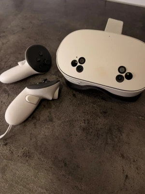 Vita VR-glasögon med handkontroller - Säljer ett par vita VR-glasögon med handkontroller. Glasögonen har flera kameror på framsidan och justerbart huvudband. Köptes för inte så länge sedan, använd väldigt få gånger. Köptes från Elgiganten för 4350 kr.