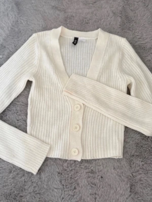 Stickad tröja med knappar från H&M 🤍✨ - Köparen står för frakt. Säljer en fin stickad tröja med knappar från H&M i storlek XS. Cremefärgad och perfekt att matcha med både jeans och kjol.  ✨ Märke: H&M✨ Färg: Cremefärgad✨ Storlek: XS✨ Skick: Bra skick. Tröjan har en liten fläck på ärmen/handleden som troligtvis är en sminkfläck och bör gå bort i tvätten. Tvättas självklart innan försäljning.  Hör gärna av dig om du har frågor eller vill ha fler bilder! 💕
