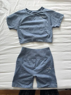 Blått peach set med shorts - Tvådelat peach set i ljusblått med kortärmad crop top och matchande shorts. Båda delar har diskret broderad persika och texten 'peach' baktill på shortsen. Mjukt och stretchigt material ❤️