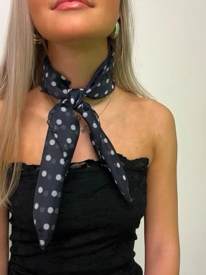 Svart prickig scarf i tunt tyg - Snygg svart scarf med vita prickar🖤🤍🖤🤍 Materialet är lätt och tunt. Jättecool detalj som piffar upp en outfit vid alla tillfällen! Kan bäras på många sätt, i håret, på väskan, runt halsen osv.