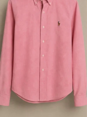 Rosa skjorta från Ralph Lauren - Säljer en rosa skjorta från Ralph Lauren i super slim fit. Skjortan har klassisk krage, knappar framtill och den ikoniska broderade loggan på bröstet. Tillverkad i mjuk bomull och har långa ärmar med knapp vid manschetten.