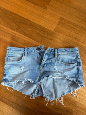 Ljusblå jeansshorts  - Säljer ett par ljusblå jeansshorts. Är storlek 38 men är ganska små i storleken så funkar nog bäst på folk som har 34-36