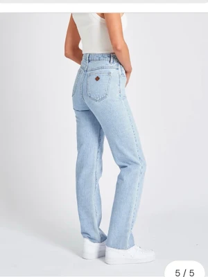 Ljusblå jeans  - Säljer ett par ljusblå Abrand jeans med rak passform och slutar på naveln, storlek 24,  passar dom med xs eller 34 i jeans. Fint skick, det ända är märket på bakfickan som syns på bilden. Köpta för 1000 kr