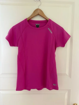 Rosa tränings-tshirt från KARHU - Snygg rosa tränings-tshirt i funktionsmaterial. T-shirten har korta ärmar, rund halsringning och ventilerande meshstruktur som passar perfekt till träning. Reflekterande logga på bröstet och nedtill. Kolla gärna mina andra annonser❗️